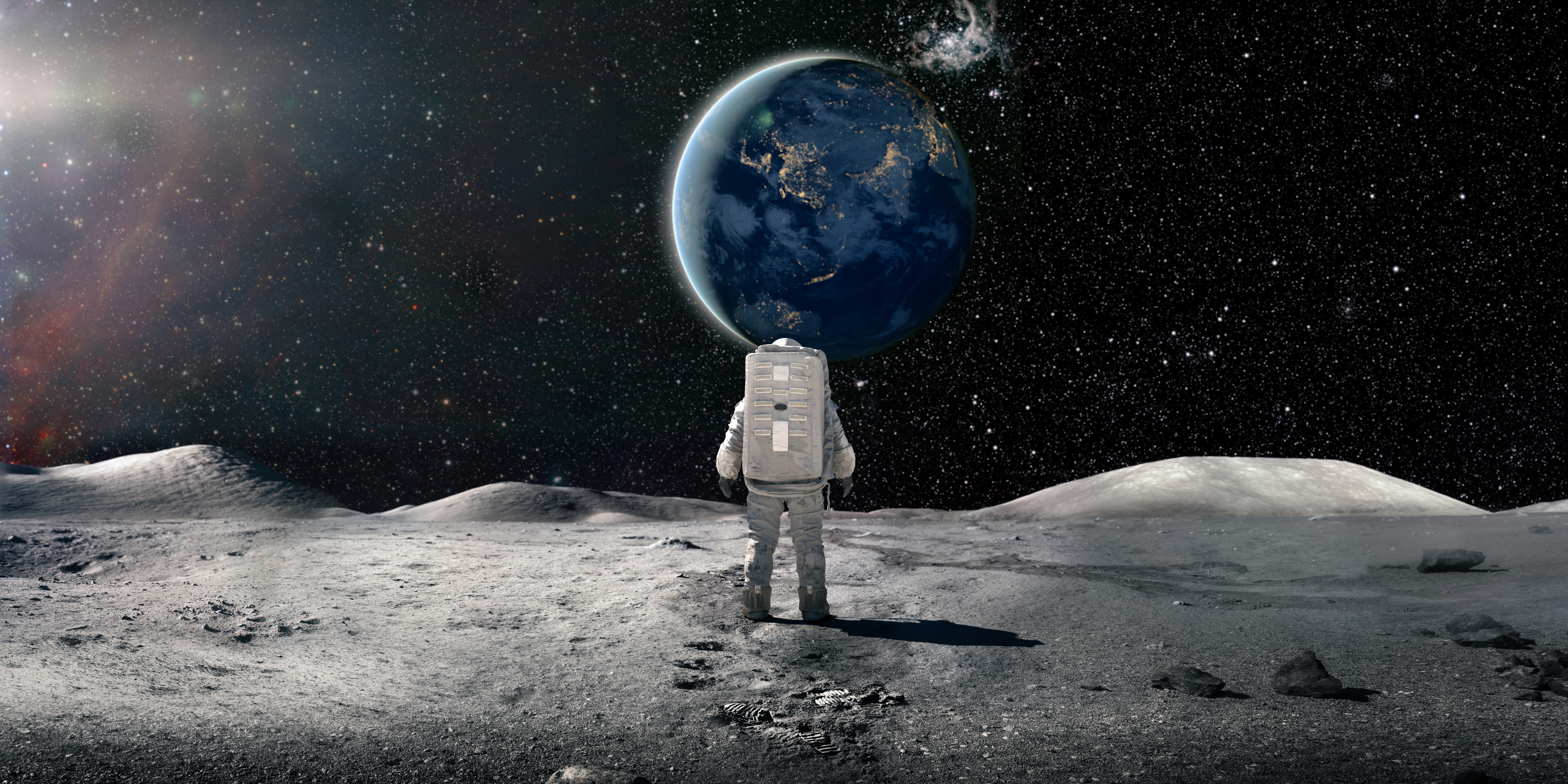 Lone Astronaut In Spacesuit Standing On The Moon Looking At The Distant Earth